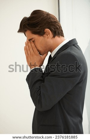Stress, anxiety and business man in office with fear, worry or desperate prayer for help on wall background. Nervous, mistake and profile of male manager with headache for startup, disaster or fail Royalty-Free Stock Photo #2376181885
