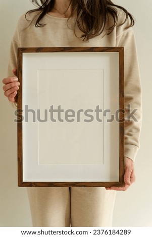 Female hanging wooden frame with empty mockup copy space Royalty-Free Stock Photo #2376184289