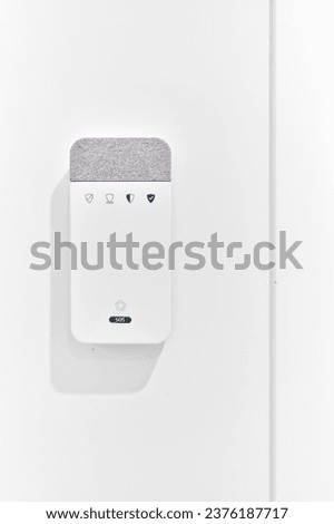Close up of contemporary alarm equipment, security panel mounted on wall in modern house against white copy space wall. SOS alarm system, security, safety, smart home concept Royalty-Free Stock Photo #2376187717