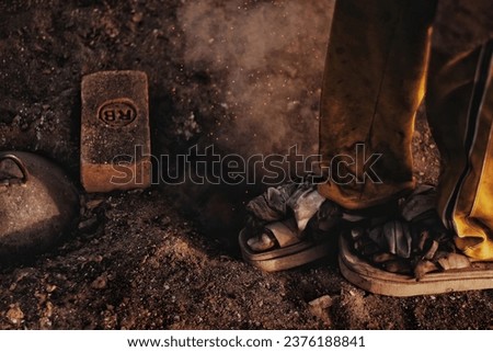 An  asian young construction man or boy working on the site. Aligning bricks on the floor. Copy space. Blurred background. 
