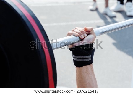Weightlifting. A man performs a bench press on a street platform. Sports competitions for amateur athletes. Close-up. Unrecognizable man Royalty-Free Stock Photo #2376215417