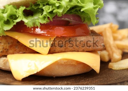 Delicious burger with tofu and fresh vegetables on wooden table, closeup