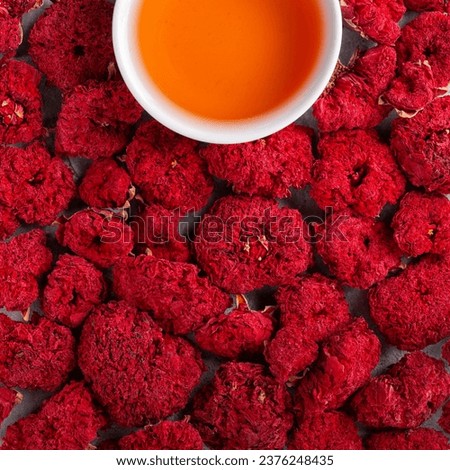 Dried pomegranate flowers and cup of pomegranate tea as food background. Pomegranate flower petals for making fruit herbal tea. Top view.