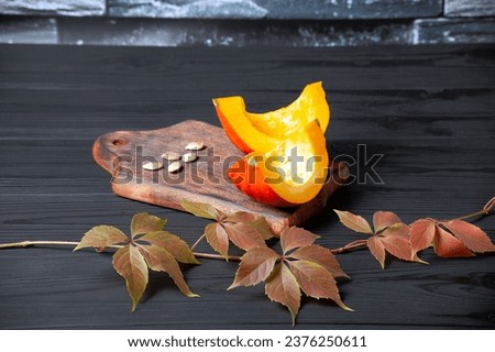 sliced pumpkin on dark wooden background. red pumpkin on table.