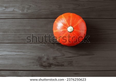 Orange pumpkin on dark wooden background. red pumpkin on table.