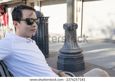 Young man in his twenty’s hanging out in a downtown urban area wearing stylish clothing causal 