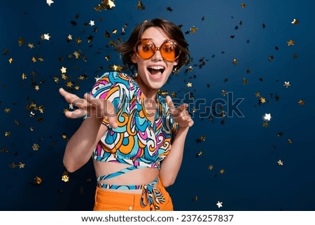 Photo of attractive young woman dancing have fun confetti lottery wear trendy flared pants clothes isolated on dark blue color background