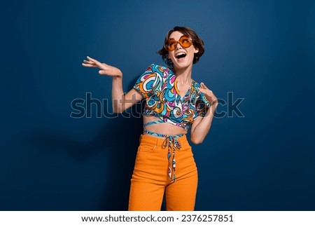 Photo of attractive woman dancing have fun look empty space wear trendy flared pants jeans clothes isolated on dark blue color background