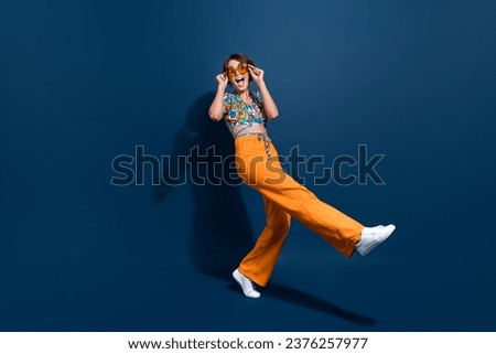 Full length photo of lovely young lady dancing energetic funky excited wear trendy flared pants isolated on dark blue color background