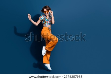 Full body photo of pretty young girl dancing have fun energetic wear trendy flared pants jeans isolated on dark blue color background