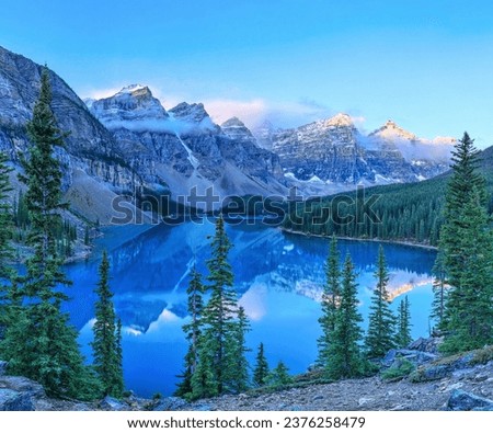 Tranquil Winter Landscape with Snow-Covered Mountains, Pine Trees, and a Calm Lake. Just hiked to the most breathtaking lake nestled amidst majestic mountains! The view is unreal! 🏔️💦 Royalty-Free Stock Photo #2376258479