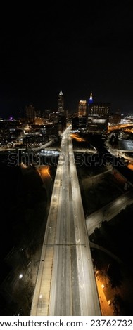 An aerial shot of the Cleveland highway, with large buildings and bright lights in the background.