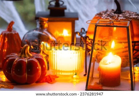 Festive decor of the house on the windowsill for Halloween - pumpkins, Jack o lanterns, skulls, cobwebs, spiders, skeletons, candles and a garland - a cozy and terrible mood