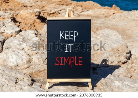 Keep it simple symbol. Concept word Keep it simple on beautiful black chalk blackboard. Beautiful stone beach sea blue background. Business motivational keep it simple concept. Copy space.