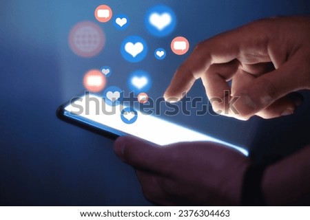 Man using smart phone. Social media concept. Use of social networks, activity on the Internet. Hands with smart phone close up view. Flying social media interaction icon Royalty-Free Stock Photo #2376304463