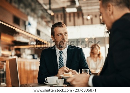 Close up of a middle aged businessman having a conversation in a cafe