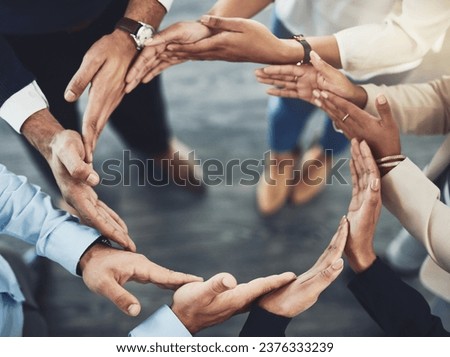 Collaboration, diversity and business people with their hands together in a circle for unity. Teamwork, friends and top view of multiracial employees with connection for team building in the office. Royalty-Free Stock Photo #2376333239