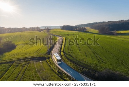 An aerial view of a bus driving through a road in a farm field in Germany 11 October 2022 Royalty-Free Stock Photo #2376335171