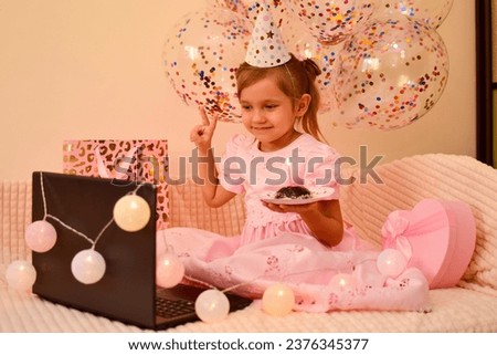 Birthday online. Child celebrates birthday by smartphone. A little girl celebrates her birthday with her parents, relatives and friends via video call. Holiday in isolation