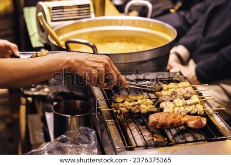 picture of an unrecognizable chef preparing food in a traditional street kitchen in Tokyo, Japan