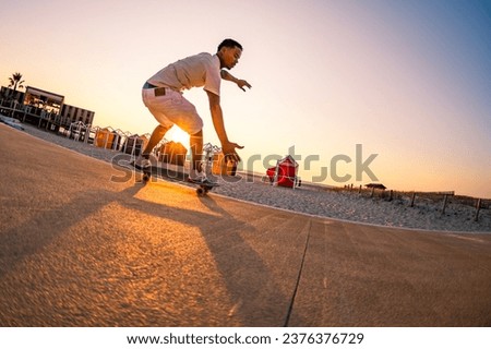 Surf skater training surfing moves near the beach at sunset. Royalty-Free Stock Photo #2376376729