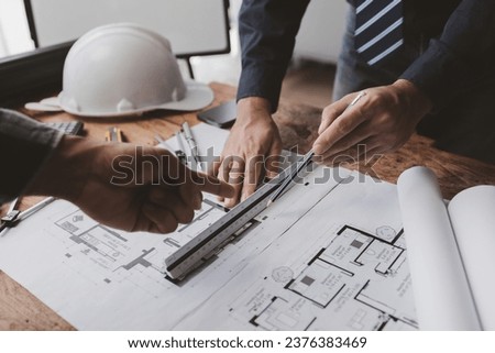 The home design architects are reviewing the house plan draft, the project commissioned by the client, and the custom design before delivery. Interior design and decoration ideas. Royalty-Free Stock Photo #2376383469