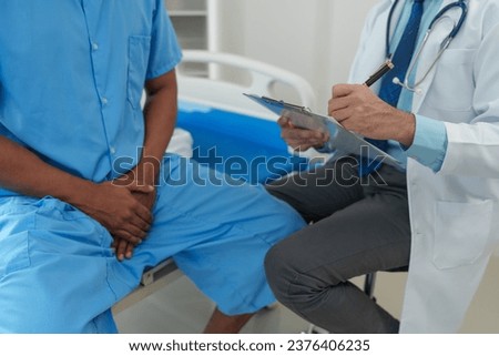 A male doctor is inquiring about the testicular cancer test report of a male patient for diagnosis and planning. Providing disease control drugs medical service concept.