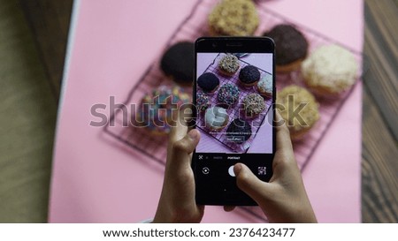 a people making food photography using smartphone with donut as an object