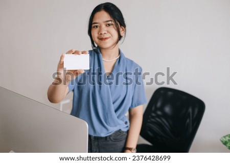 Businesswoman holding and showing white business card or blank card name in hands. Template for your design. Business card mock up.