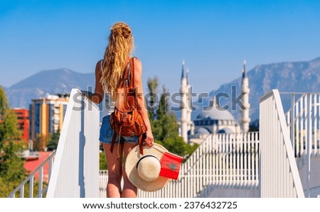 Woman tourist holding Albanian flag enjoying view of Tirana city,  beautiful mosque- Albania in the Balkans Royalty-Free Stock Photo #2376432725