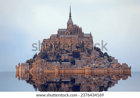 famous monastery of Mont Saint Michel with the Abbey church built above the hill during high tide in northern France in the Normandy region Royalty-Free Stock Photo #2376434169