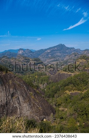Close up vertical picture of the brown gray rocks and mountains in Wuyishan, China. Blue sky with copy space for text