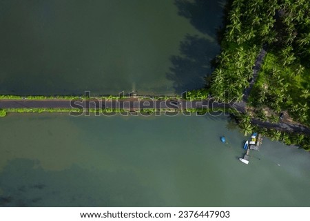 Aerial drone view of Kerala village road with river, Top down shot of Kavvayi Island Kannur Royalty-Free Stock Photo #2376447903