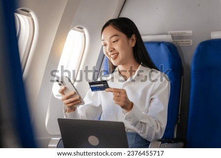 Using mobile and credit card, cashless payment, Thoughtful asian people female person onboard, airplane window, perfectly capture the anticipation and excitement of holiday travel. chinese, japanese. Royalty-Free Stock Photo #2376455717