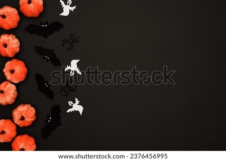 Layout of Halloween decorations on a black background: pumpkins, bats, ghosts, spiders, top view. Flat lay.