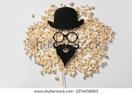 Scattered delicious popcorn and photo booth prop for movie party.