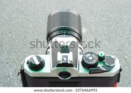 Close up a back side  veiw of a vintage film camera with black lens on road surface background