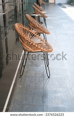 several brown rattan chairs are lined up facing the open garden and receive morning sunlight