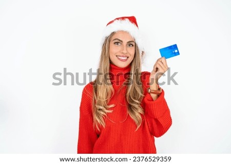 Photo of happy cheerful smiling positive Beautiful hispanic woman wearing christmas hat  recommend credit card