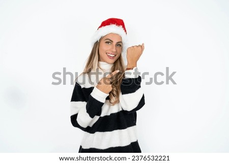 Young beautiful woman In hurry pointing to wrist watch, impatience, looking at the camera with relaxed expression