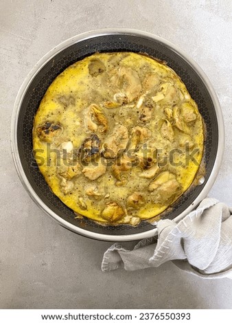 Greek food pan, artichoke omelette in a frying pan on a grey minimal background, aerial food photography picture