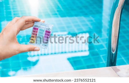 Pool tester test kit in girl hand over water background, water quality testing, quality test kit for swimming pool water Royalty-Free Stock Photo #2376552121