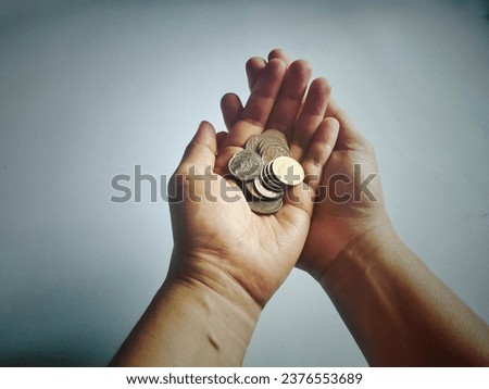A handful of coins sat in both hands as if it were the most valuable thing. Royalty-Free Stock Photo #2376553689