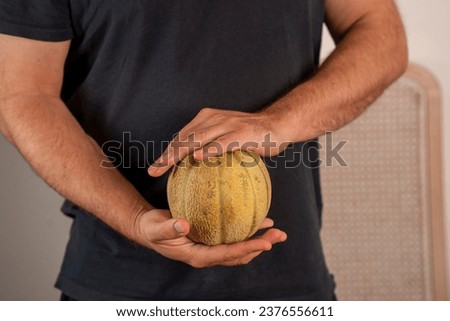man's hands holding a melon