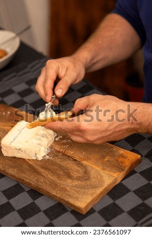 male hands spreading soft cheese on toast
