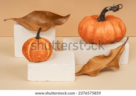 Pumpkin on a stone podium pedestal, showcase for product presentation. Autumn product promotion. Beige background with Halloween pumpkin