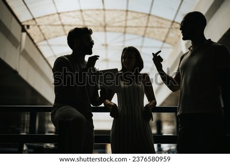 Business group discussing work outdoors, demonstrating teamwork, leadership, and innovation. Focused on productivity, profit, and new opportunities. Silhouette shot. Royalty-Free Stock Photo #2376580959