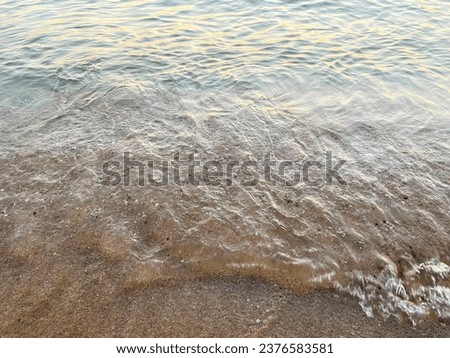 waves on the beach at sunset.