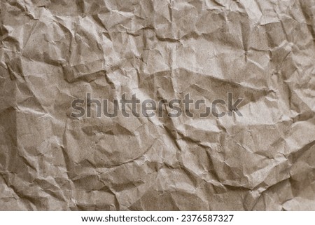 Unbleached plain wrapping paper. Eco-friendly Biodegradable Kraft Wrapping Paper. Sheet of crumpled kraft paper in brown color, background, texture, cellulose recycling, waste paper concept. 