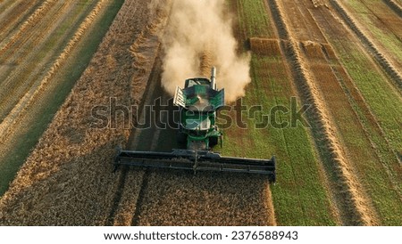 Combine harvester on grain harvest. Wheat harvesting in field. Wheat and soybeans. Wheat and corn markets in crisis world’s breadbasket. Farm field with Rye. Green Harvester on harvesting in field